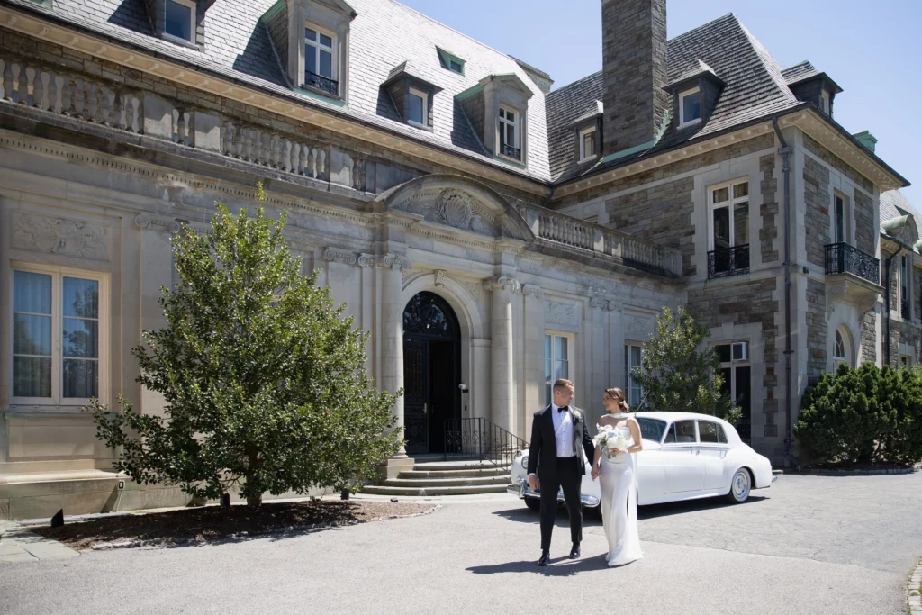 Couple walking hand in hand away from Aldrich Mansion in Newport, RI. A vintage Rolls Royce behind them.