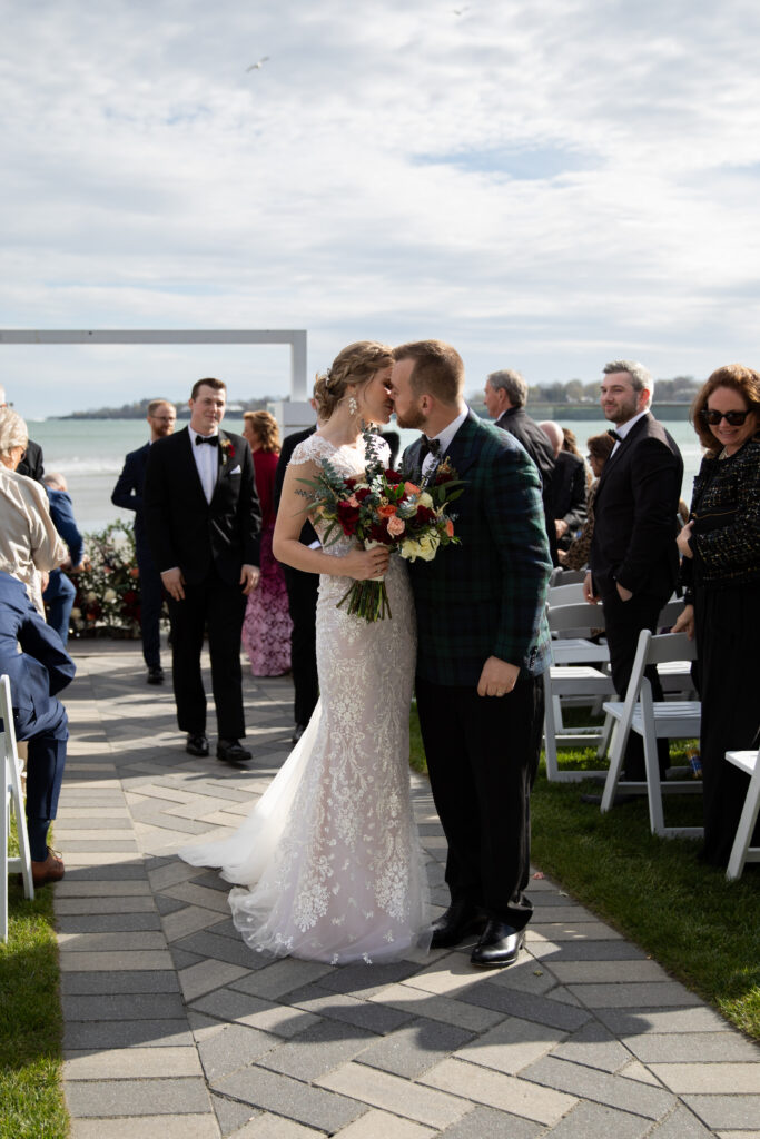 Couple leaning in for a kiss as they leave there ceremony on the back patio at Newport Beach House