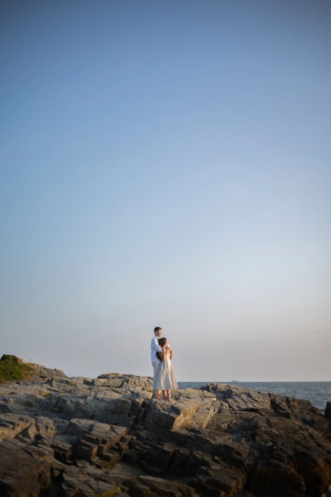 Couple looking into the ocean at Collins Beach in Newport Rhode Island Engagement Session